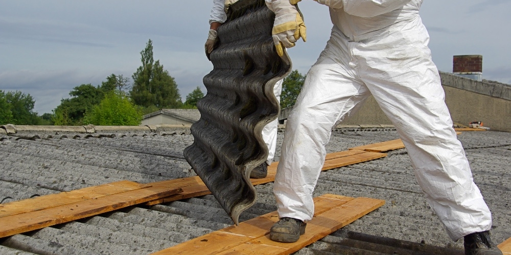Men removing asbestos roofing tiles