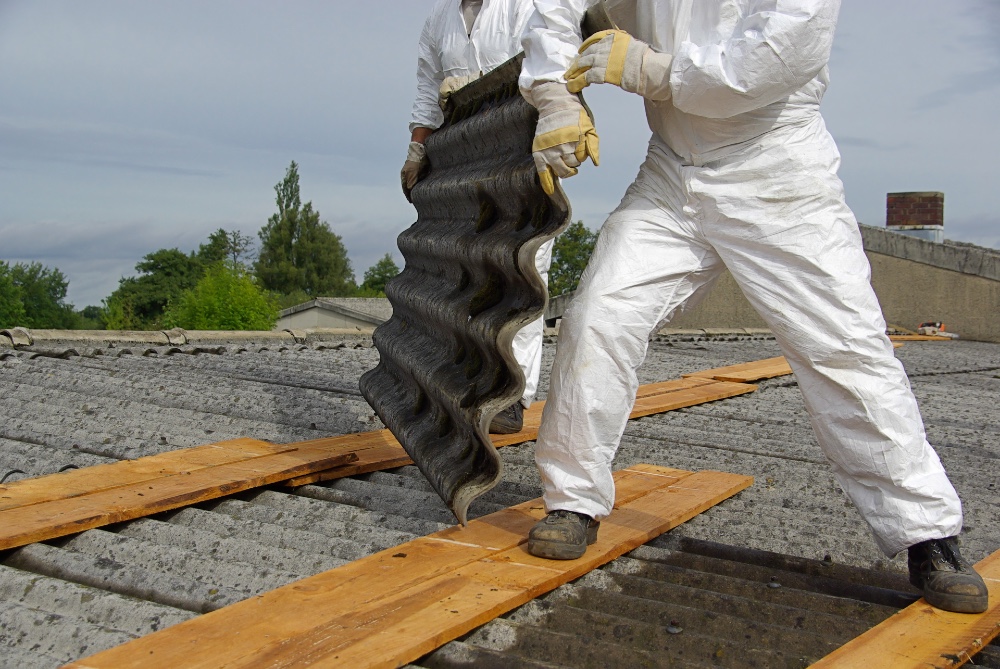 Men removing asbestos roofing tiles